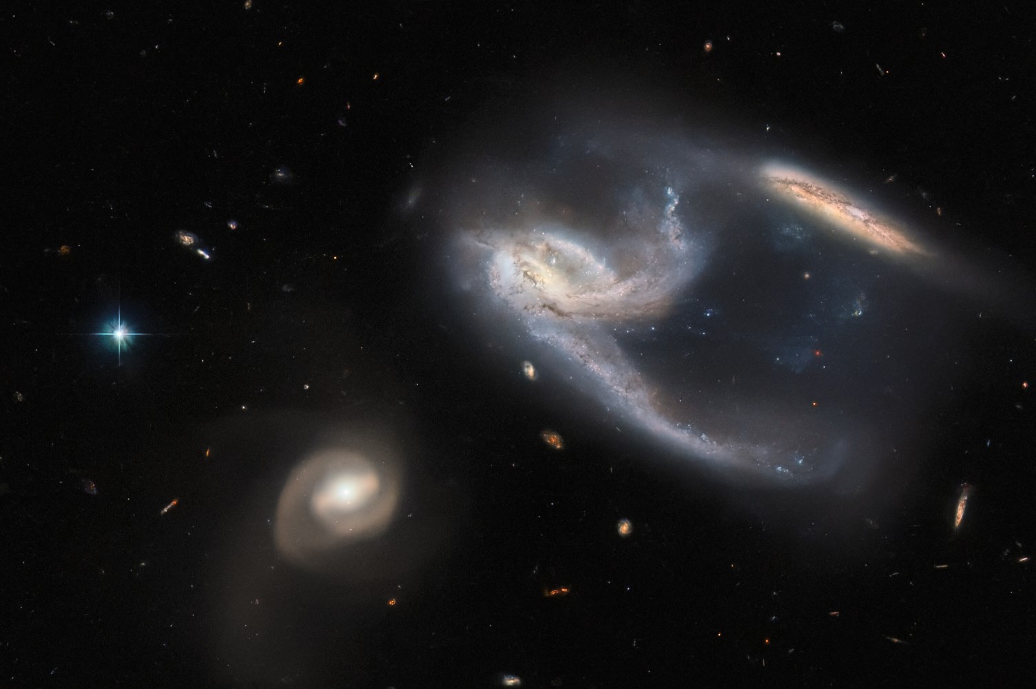 Skupina od tri galaksije, poznata kao NGC 7764A. Izvor: ESA/Hubble & NASA, J. Dalcanton, Dark Energy Survey, U.S. Department of Energy (DOE), Fermilab (FNAL), Dark Energy Survey Camera (DECam), Cerro Tololo Inter-American Observatory (CTIO), NoirLab/National Science Foundation/AURA, European Southern Observatory (ESO); Acknowledgment: J. Schmidt.