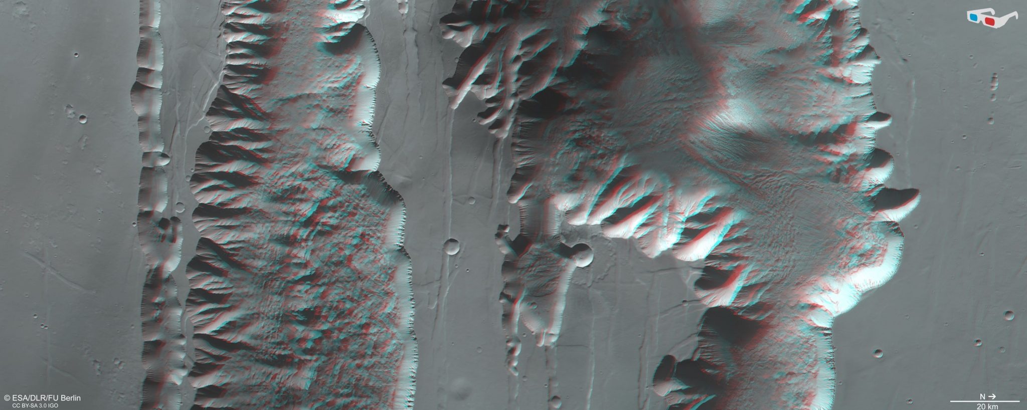 'Ius' i 'Tithonium Chasmata' – dijelovi ('rovovi' ili klanci) kanjona Valles Marineris na Marsu. Slika je stvorena pomoću stereo kamere visoke rezolucije (HRSC) na ESA-inom Mars Expressu 21. travnja 2022. godine (©ESA/DLR/FU Berlin, CC BY-SA 3.0 IGO).
