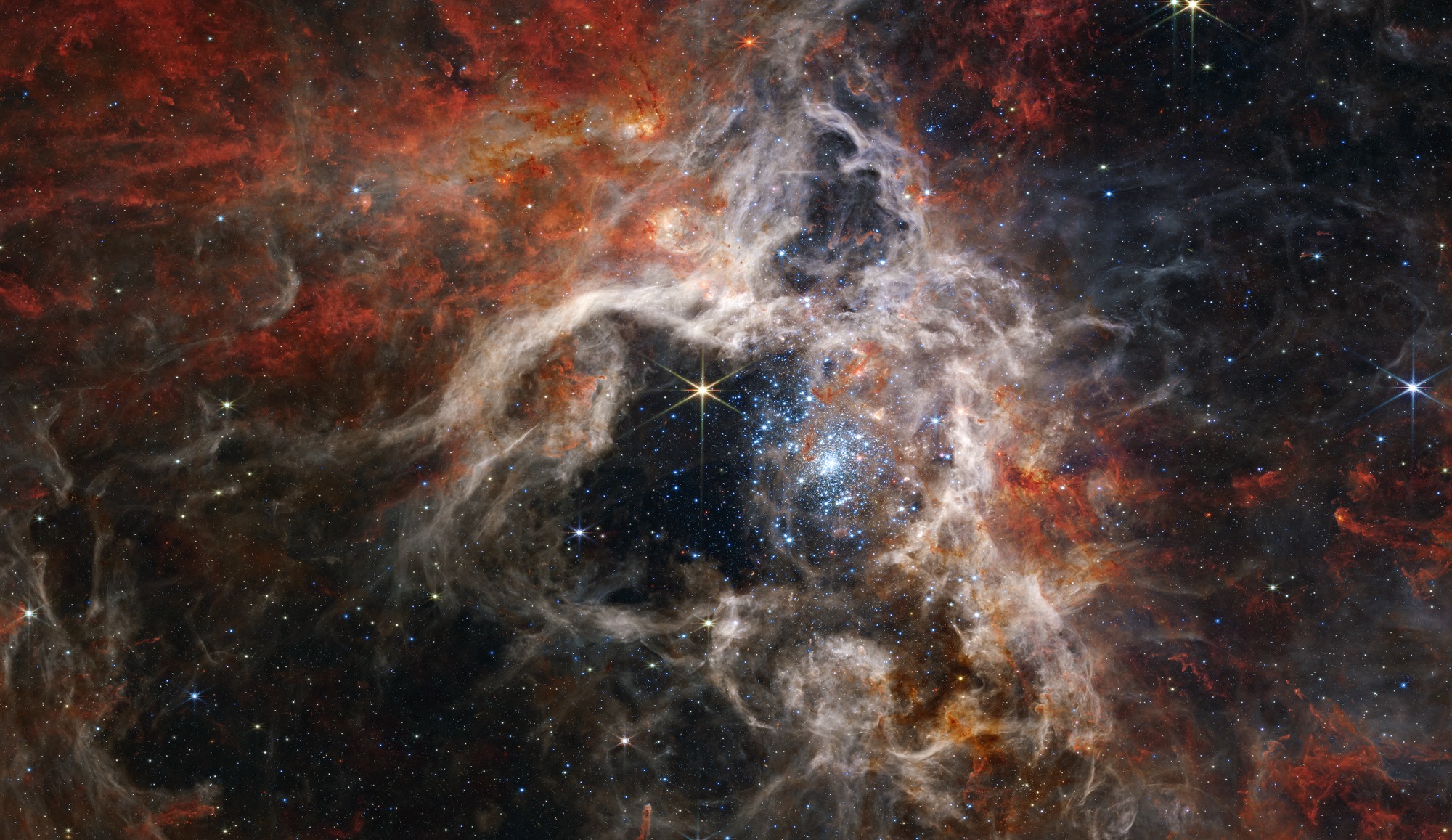 Na ovom mozaiku slika – koji se proteže preko 340 svjetlosnih godina – Webbova kamera (NIRCam) snimila je područje nastajanja zvijezda unutar maglice Tarantula u nikada prije viđenim detaljima, uključujući desetke tisuća prethodno nepoznatih mladih zvijezda (©NASA/ESA/CSA et al).