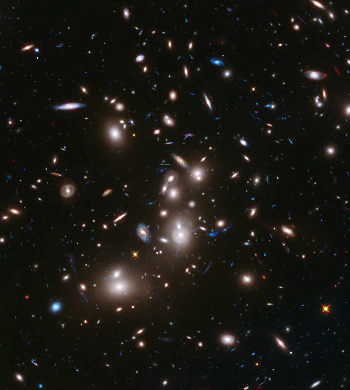 Slika galaktičkog skupa (ili klastera) Abell 2744 koji je snimio svemirski teleskop Hubble 24. studenoga 2013. godine. Udaljena 3.5 milijardi svjetlosnih godina skup sadrži nekoliko stotina galaksija i vjerojatno je nakupina najmanje četiri manja jata galaksija. Snažno gravitacijsko polje Abella 2744 djeluje kao leća, osvjetljavajući i povećavajući svjetlost gotovo 3000 udaljenih pozadinskih galaksija (©NASA).