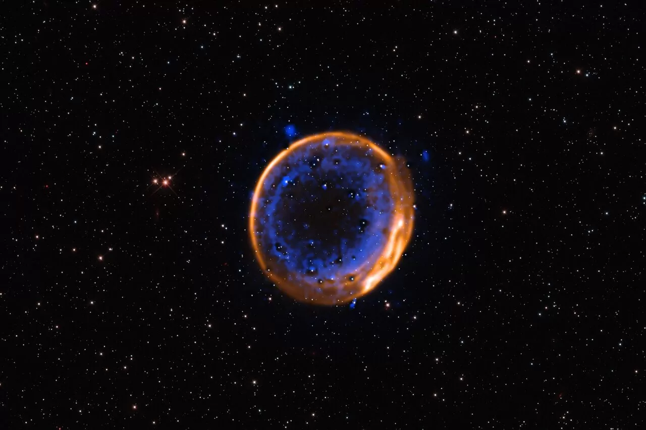 Ova fotografija, snimljena ESO-ovim Vrlo velikim teleskopom (VLT), prikazuje ostatke supernove SNR 0509-67.5 — šireći oblak materijala nastao nakon eksplozije zvijezde prije nekoliko stoljeća. Riječ je o prvom fotografskom dokazu da zvijezde mogu završiti život s dvostrukom detonacijom. Podaci su prikupljeni instrumentom MUSE, koji omogućuje mapiranje kemijskih elemenata. Kalcij, prikazan plavom bojom, raspoređen je u dva koncentrična sloja — jasan trag dvostruke eksplozije. Izvor: ESO/P. Das i sur.; pozadinske zvijezde (Hubble): K. Noll i sur.