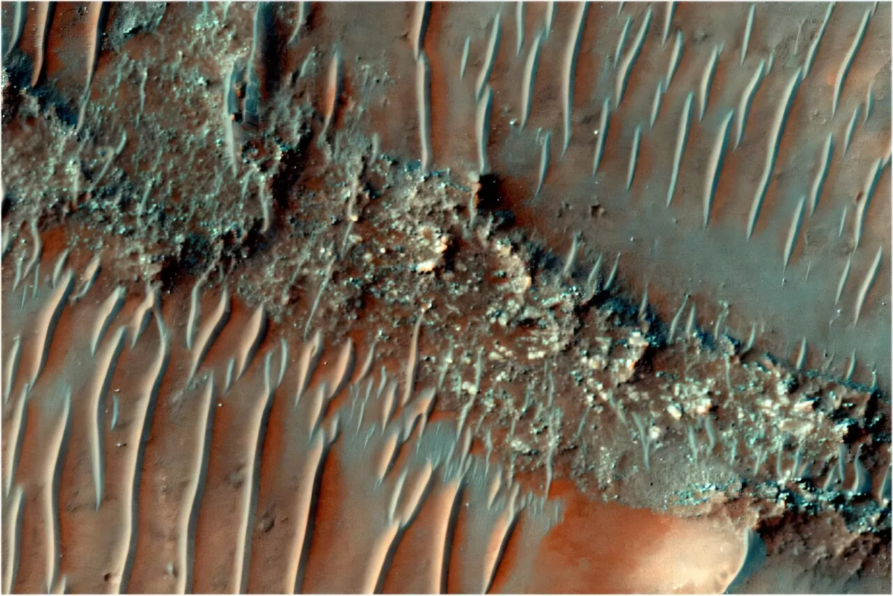 Obojena snimka ravnog, snažno erodiranog grebena FSR. Preko njegove površine prelaze pomične pješčane dine. Izvor: HiRISE snimka ESP_085386_1505, NASA/JPL/University of Arizona.
