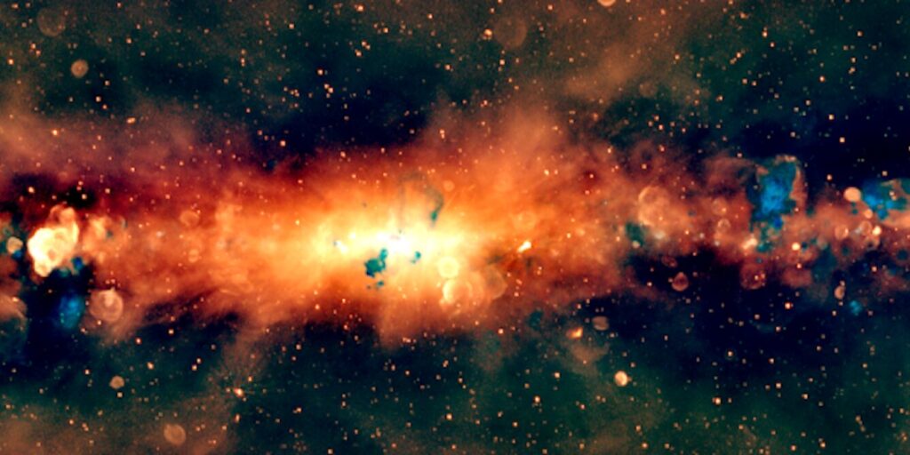 Novi radijski portret središta Mliječne staze snimljen pomoću teleskopa Murchison Widefield Array. Galaksija je prikazana u „radijskim bojama“, pri čemu narančasta označava najniže frekvencije, zelena srednji raspon, a plava najviše. Zasluge: Silvia Mantovanini (ICRAR/Curtin) i tim GLEAM-X.