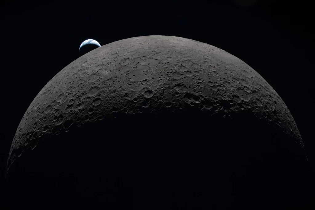 Na ovoj fotografiji koju je posada misije Artemis II snimila 6. travnja 2026. tijekom leta oko dalje strane Mjeseca vidi se Zemlja kako zalazi iza njegova zakrivljenog obzorja. Uz vidljivi dio Mjesečeve površine raspoznaje se bazen Orientale, dok se Hertzsprung nazire kao dva blaga koncentrična prstena koje presijeca mlađi krater Vavilov. Nizovi udubina sekundarni su lanci kratera nastali od materijala izbačenog pri golemom udaru koji je oblikovao Orientale. Tamni dio Zemlje uronjen je u noć, a na osvijetljenoj strani vide se oblaci iznad Australije i Oceanije. Zasluge: NASA