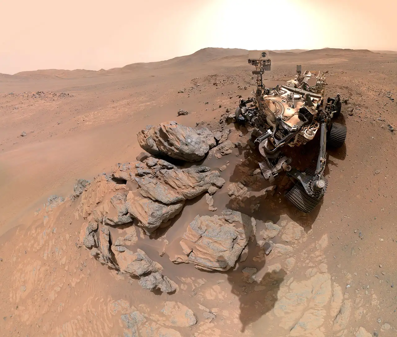 NASA-in rover Perseverance na površini Marsa, uz stijenu Arethusa, s rubom kratera Jezero u pozadini.