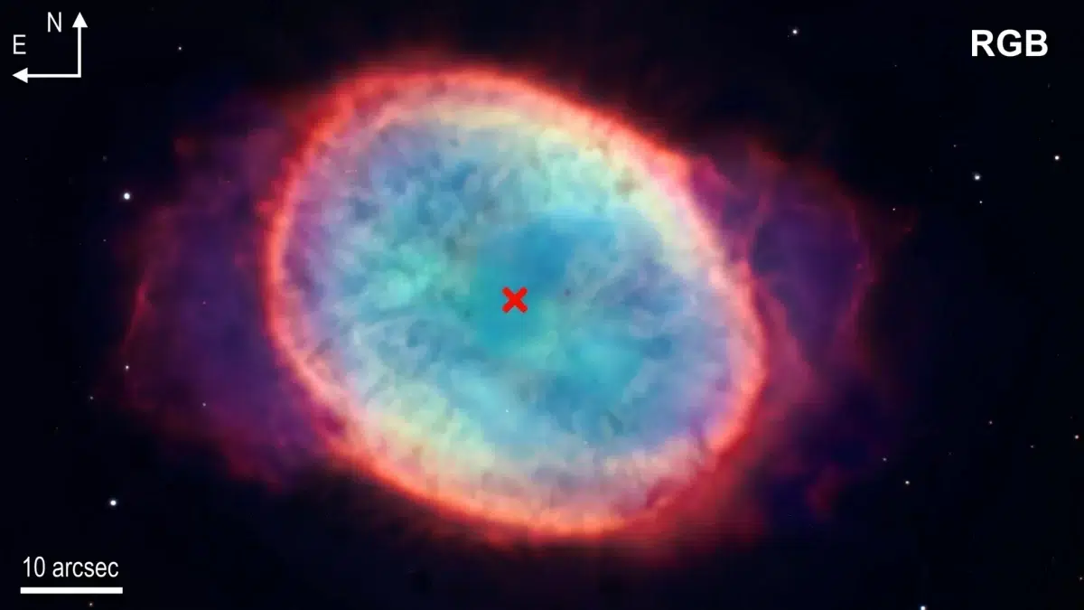 RGB kompozitna fotografija NGC 6563 prikazuje prostorni raspored glavnih emisijskih linija maglice, pri čemu su [N II], Hα i [O III] dodijeljeni crvenom, zelenom i plavom kanalu. Crveni križ označava položaj središnje zvijezde prema katalogu Gaia DR3. Zasluge: Al i sur., 2026. Kozmos.hr