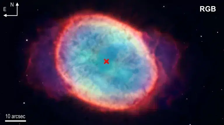 RGB kompozitna fotografija NGC 6563 prikazuje prostorni raspored glavnih emisijskih linija maglice, pri čemu su [N II], Hα i [O III] dodijeljeni crvenom, zelenom i plavom kanalu. Crveni križ označava položaj središnje zvijezde prema katalogu Gaia DR3. Zasluge: Al i sur., 2026. Kozmos.hr