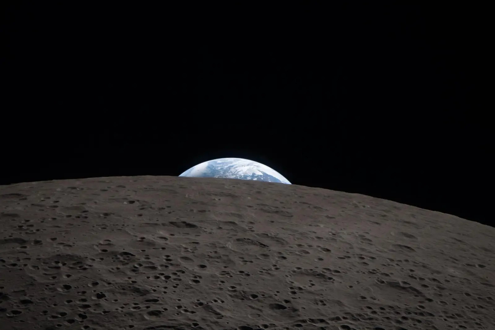 Zemlja izranja iznad mjesečeva horizonta snimljena iz letjelice Orion.