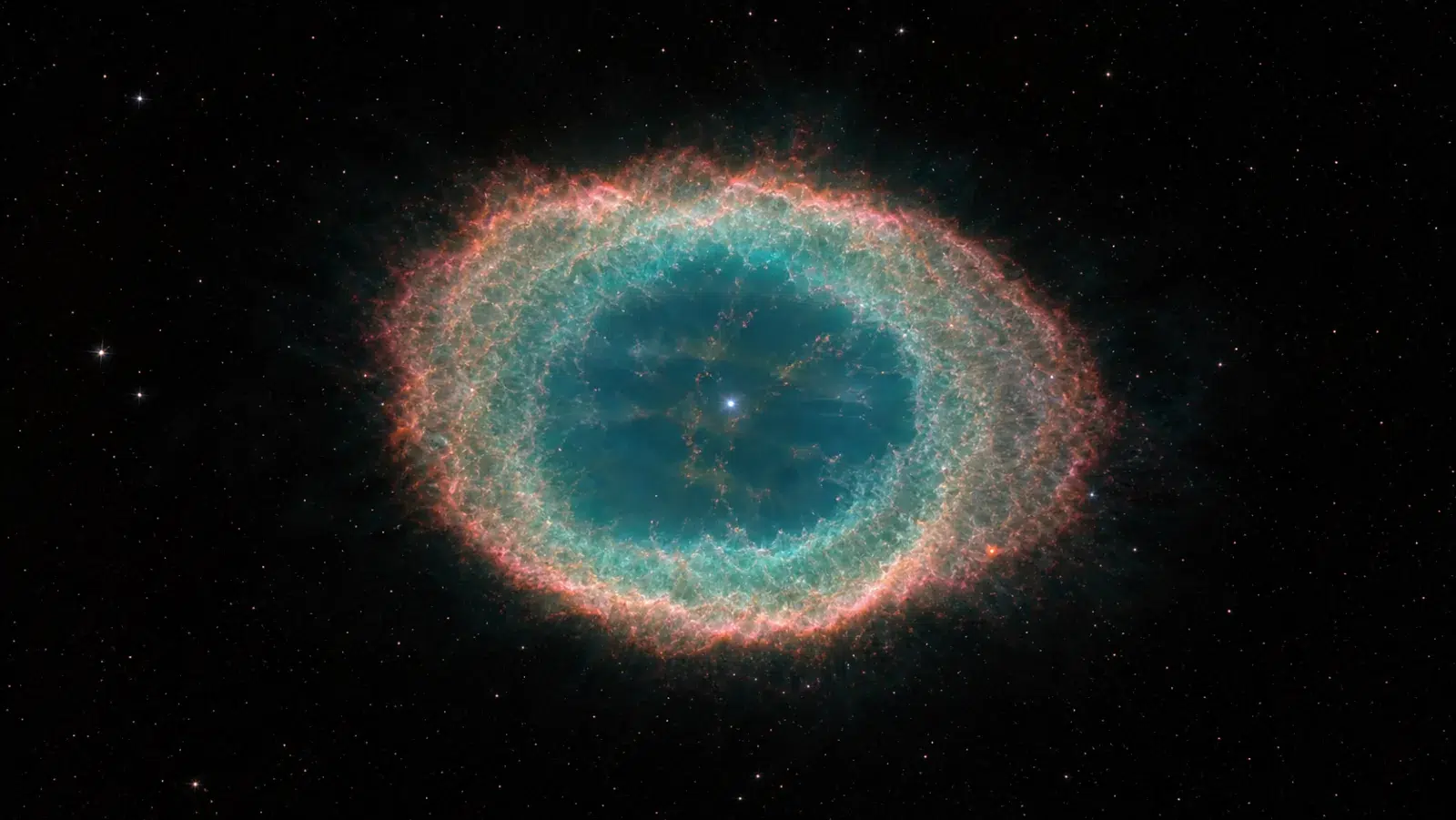 Svjetleća planetarna maglica s plavozelenim plinom, crvenkastim rubovima i sjajnom središnjom zvijezdom