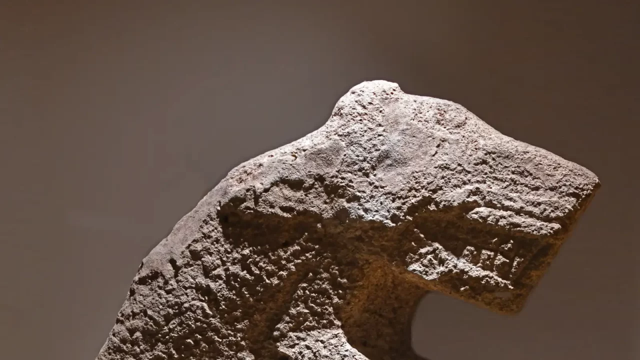 Kamena neolitička skulptura čovjeka na leđima leoparda u muzejskoj vitrini