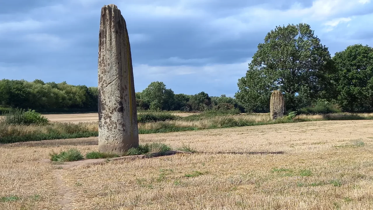 Dva kamena monolita Devil's Arrows na polju kod Boroughbridgea, uz drveće.