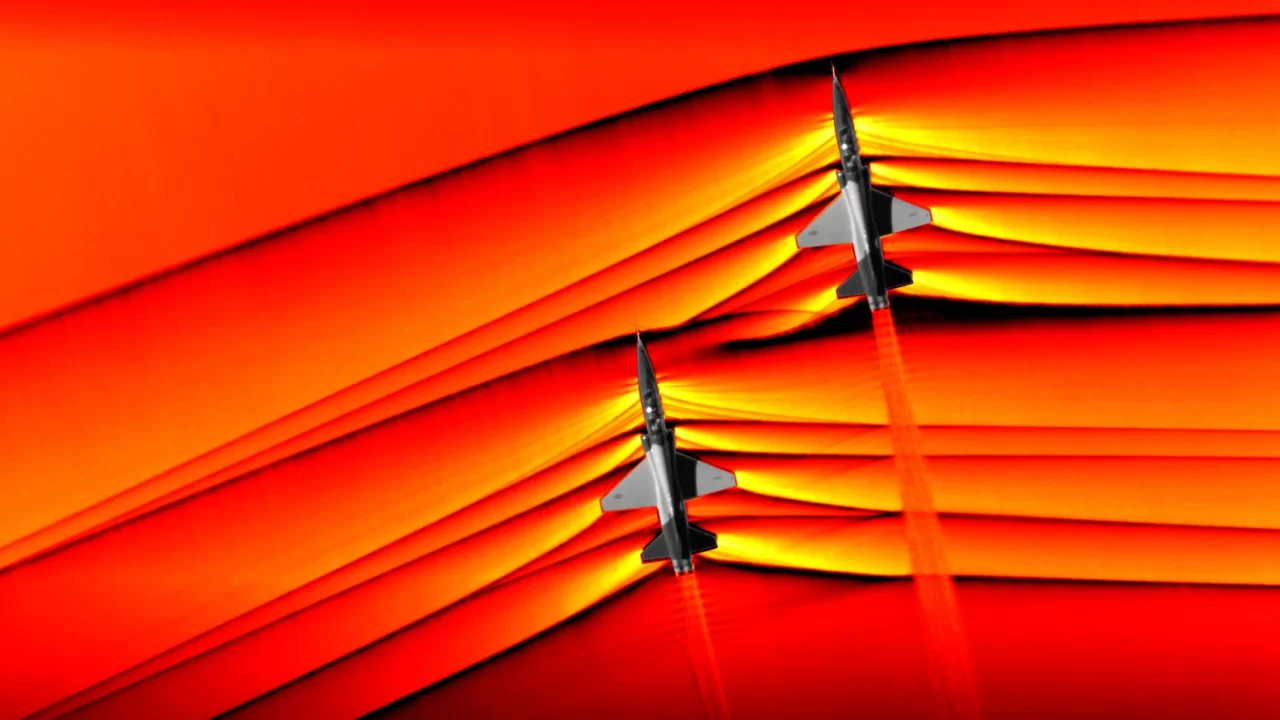 Dva aviona T-38 s udarnim valovima prikazanima u crvenim i žutim tonovima
