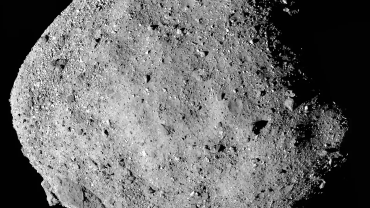 Asteroid Bennu na crnoj pozadini, s osvijetljenom stjenovitom površinom i brojnim gromadama.