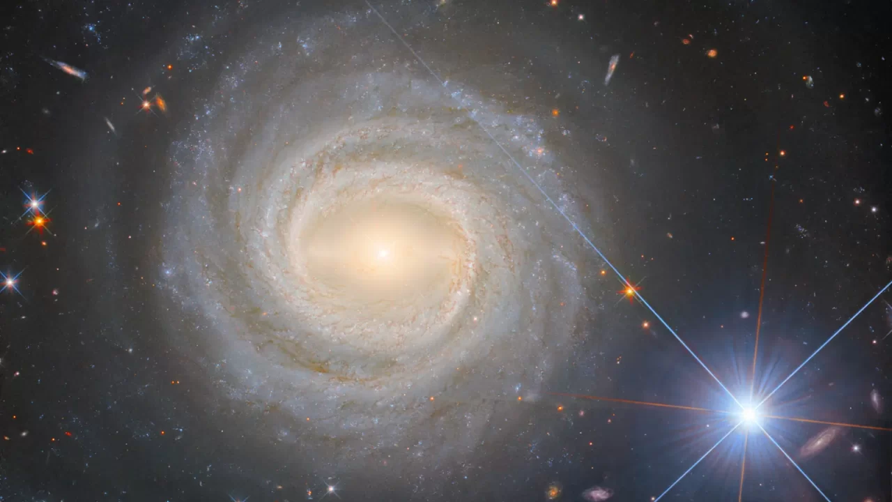 Spiralna galaksija NGC 3783 sa sjajnom jezgrom i svijetlom zvijezdom u prednjem planu.