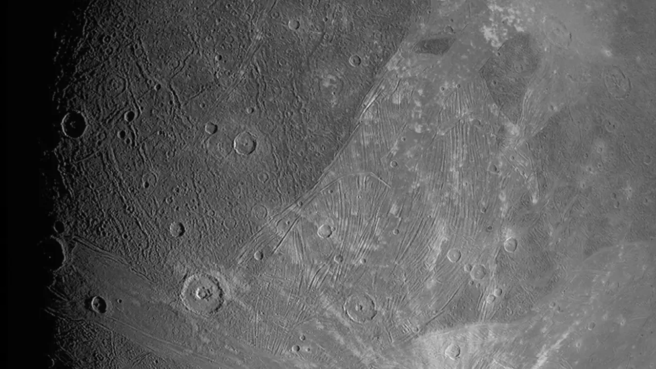 Ganimedova izbrazdana površina i krateri na crno-bijeloj snimci letjelice Juno.