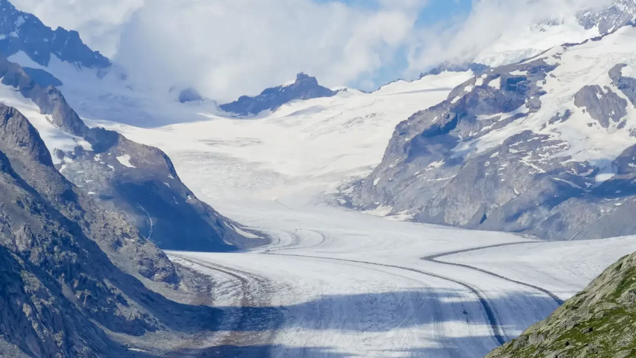 Ledenjak Aletsch s tamnim prugama morenskog materijala između stjenovitih alpskih padina
