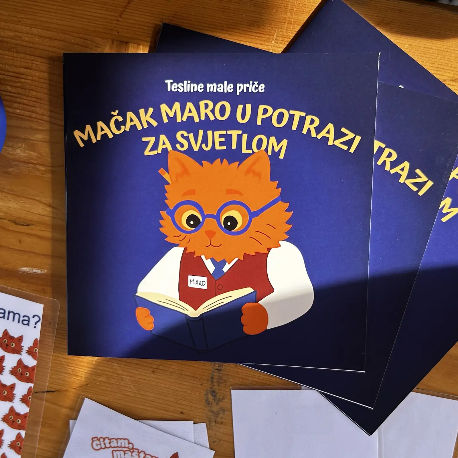 Primjerci slikovnice Mačak Maro u potrazi za svjetlom na drvenom stolu