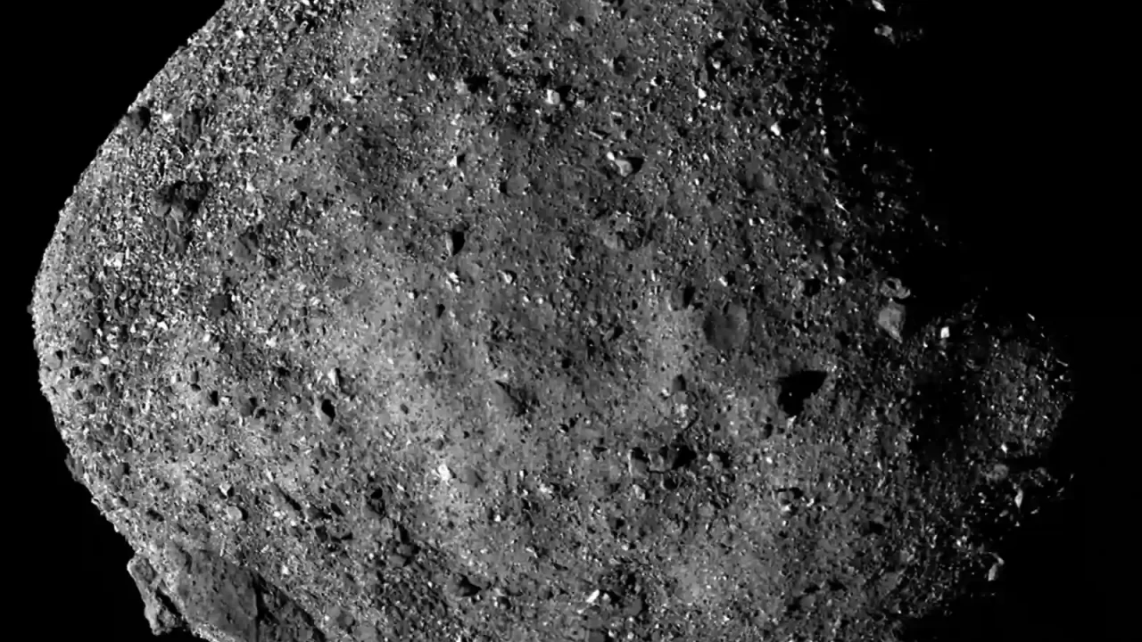 Crno-bijeli mozaik asteroida Bennu s neravnom površinom prekrivenom stijenama.