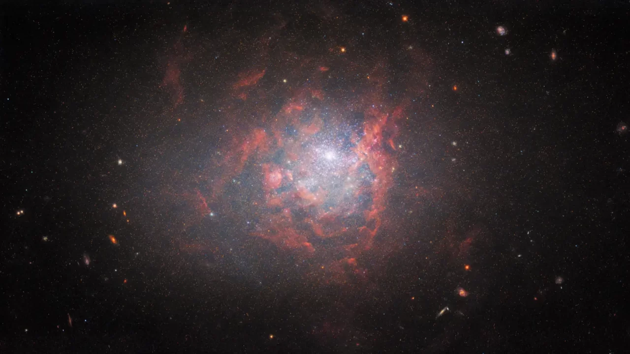 Sjajna jezgra galaksije NGC 1705 okružena plavičastim zvijezdama i raspršenim plinom.