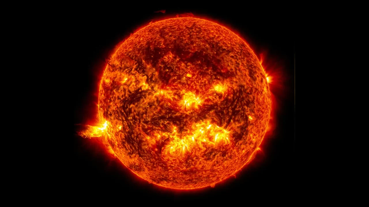 Crvenonarančasti Sunčev disk s istaknutim svijetlim područjima na crnoj pozadini