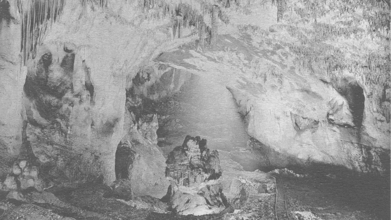 Crno-bijela arhivska fotografija velike špiljske dvorane sa stjenovitim stupovima i sigama u Isturitzu.